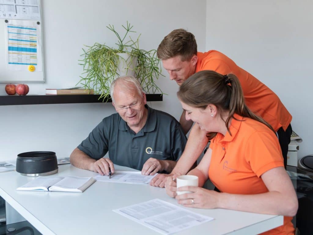 Foto-3-mensen-in-overleg-aan-tafel